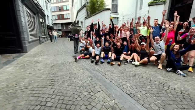 Groupe de coureurs WeRun Liège fêtant la fin d'un run social dans les rues de Liège